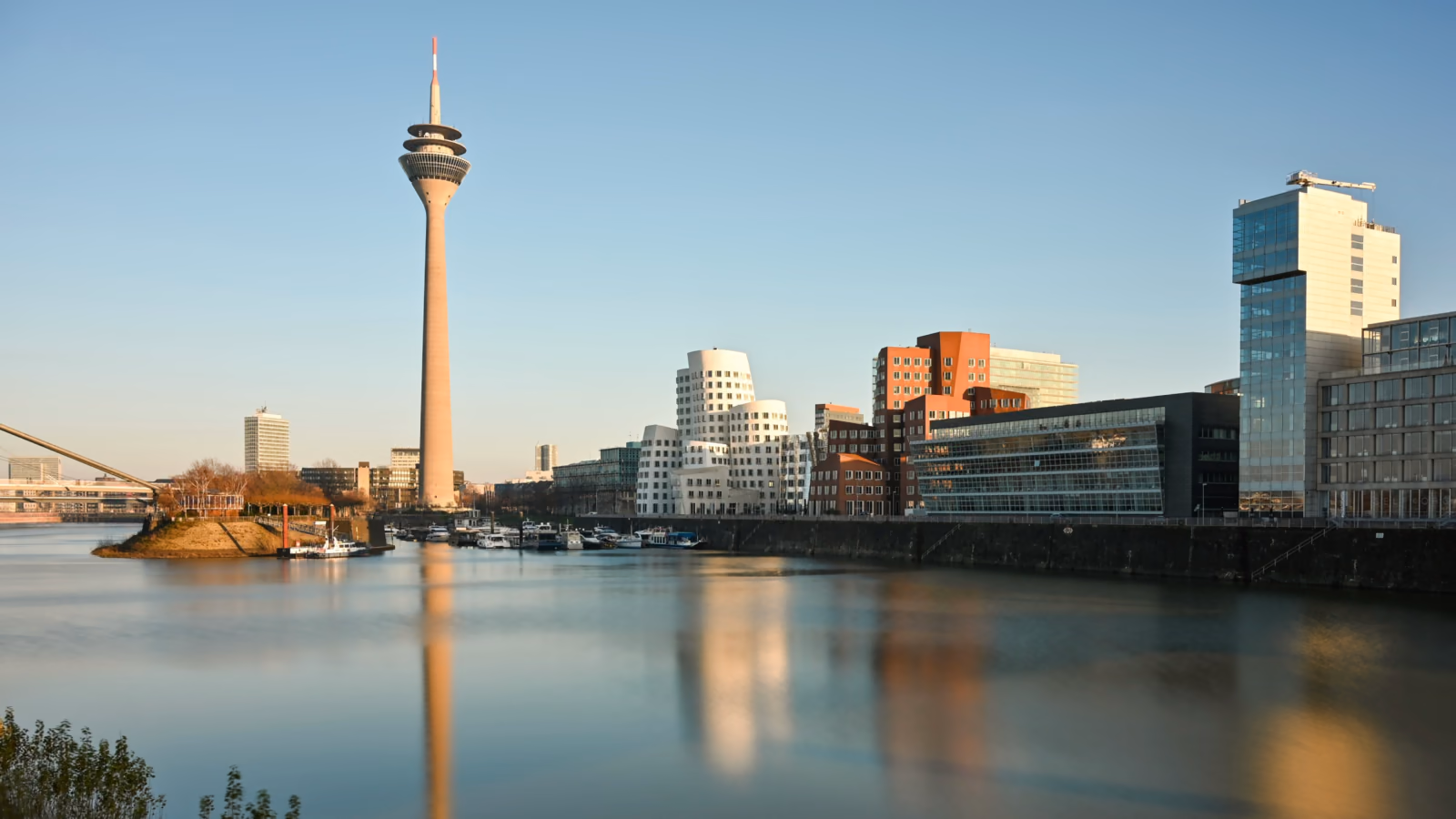 Düsseldorf’s Medienhafen with the Rheinturm and the Gehry buildings reflected in the harbor basin.